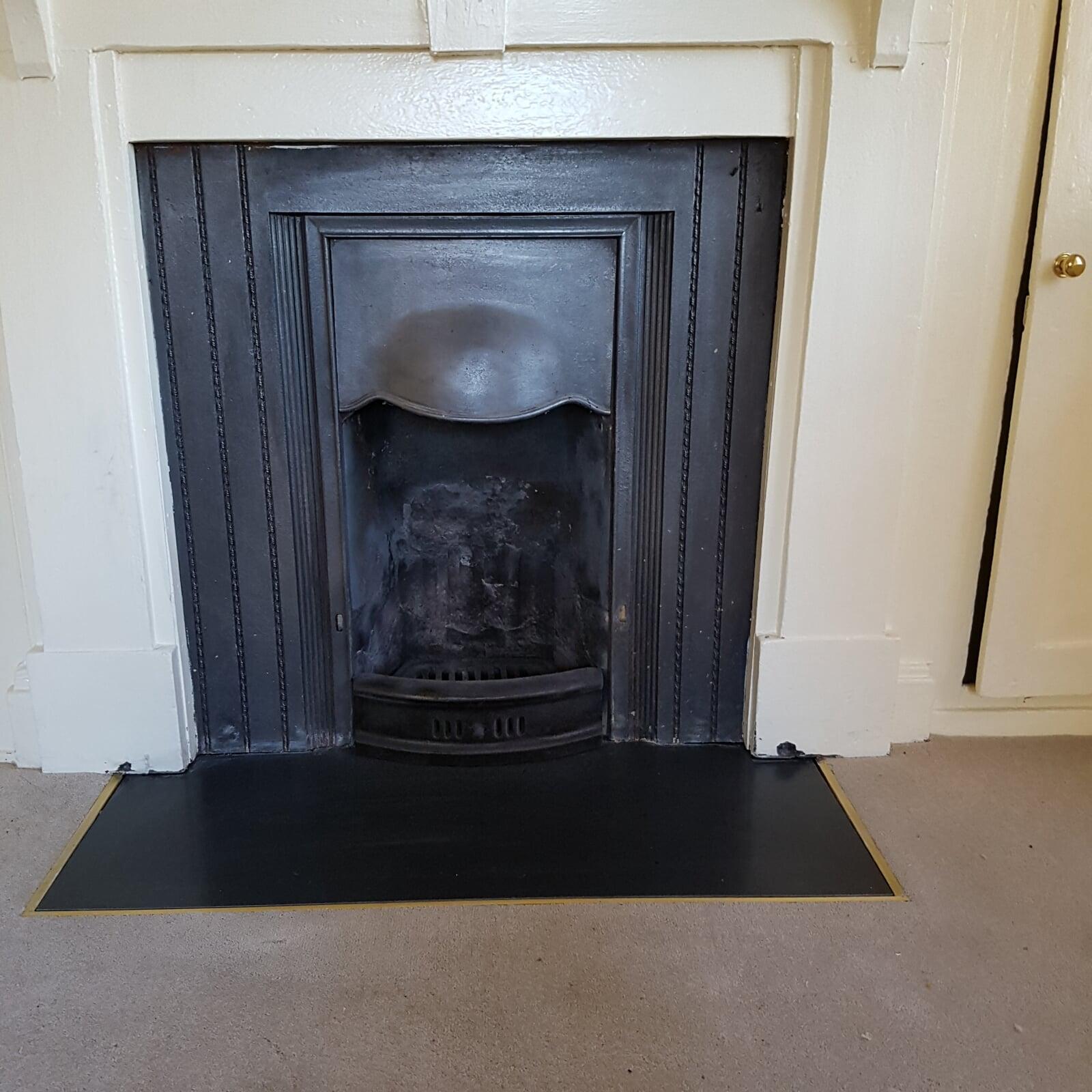 Cast fireplace in bedroom with sunken granite hearth